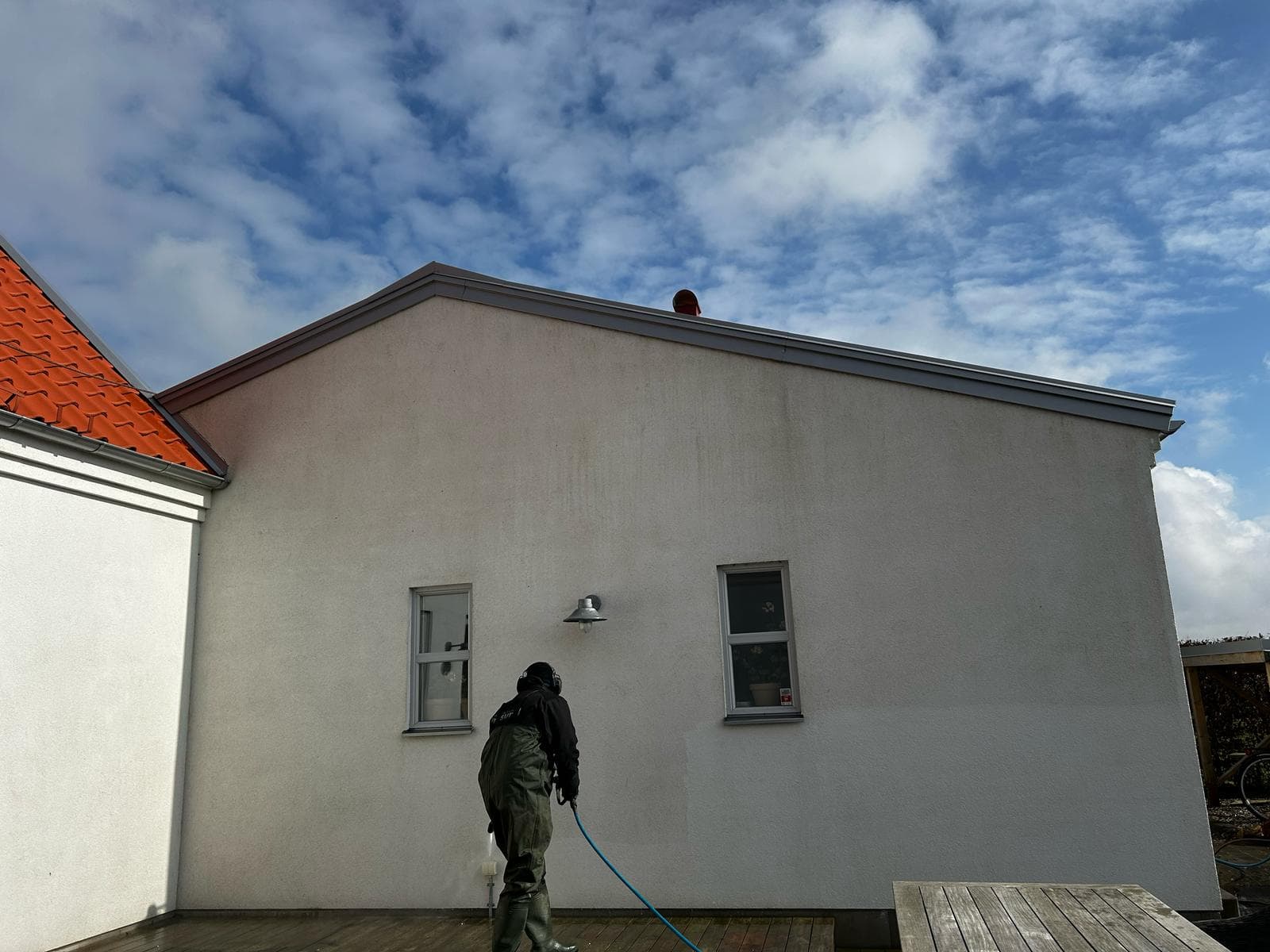 Tekniker utför fasadbehandling på putsad villa i Skåne